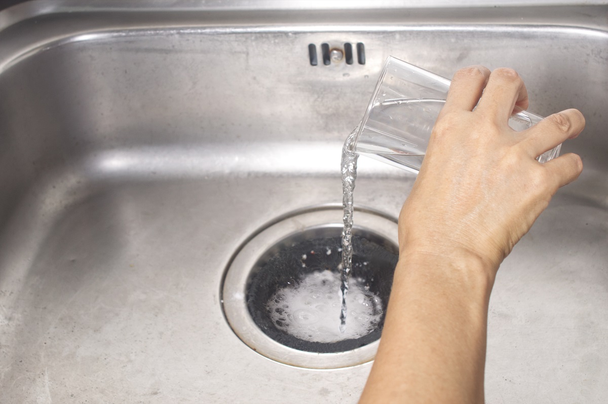 https://www.christiansonco.com/wp-content/uploads/2020/08/pour-glass-of-vinegar-into-the-drain-of-the-sink.jpg