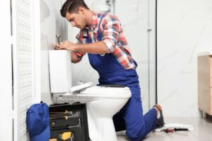 Professional plumber installing a low flow toilet